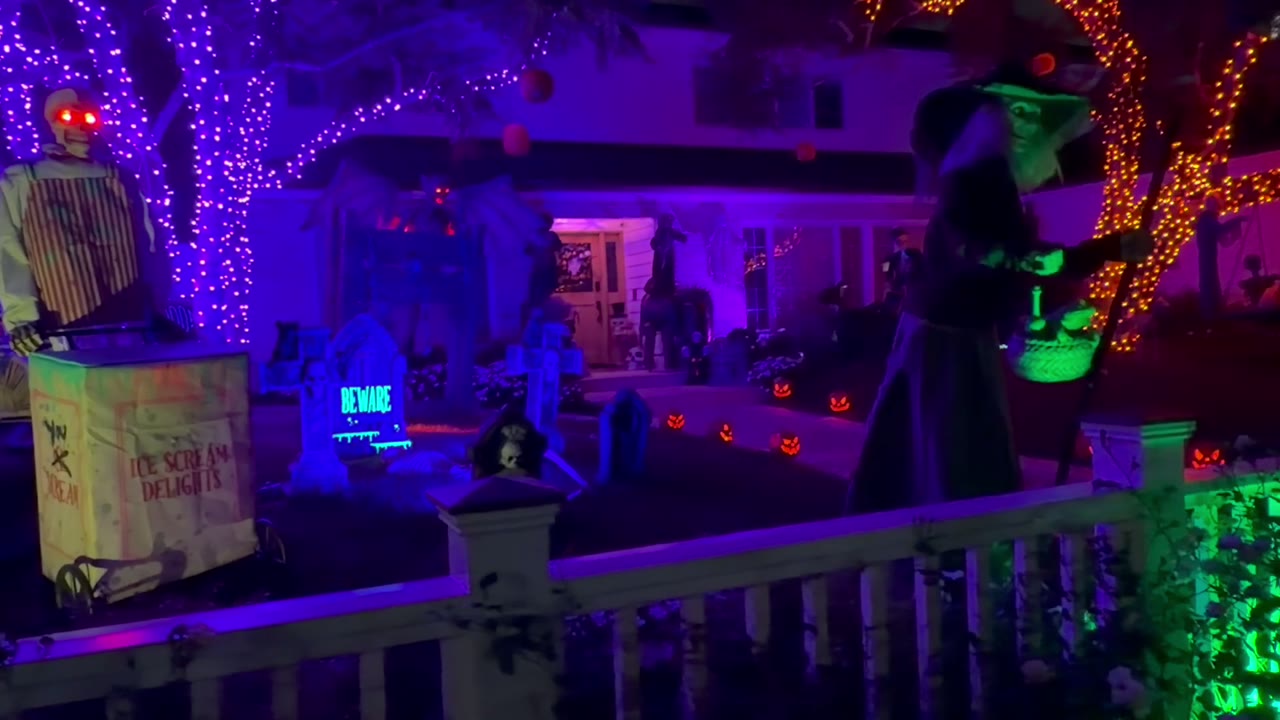Real Halloween lighting display with purple trees and illuminated decorations at night